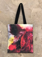 Load image into Gallery viewer, The Anish Kapoor tote bag lying flat. The bag has a black handle and printed front displaying a swirling red and black pattern on a light background.