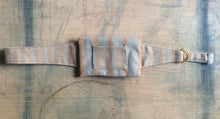 Load image into Gallery viewer, A waist bag in a striped grey and brown material with the straps spread out. There is a brass clasp on the right side.