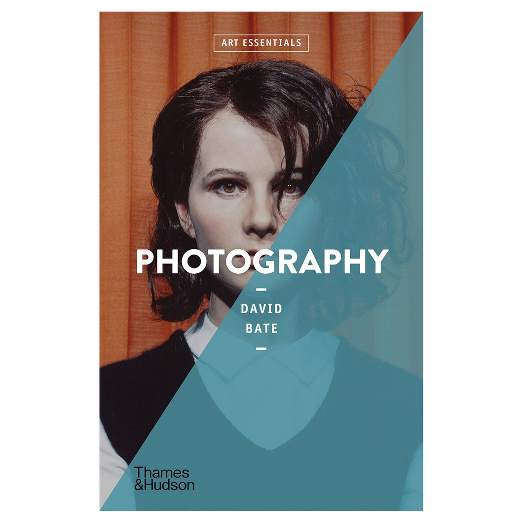 A rectangular book featuring a portrait of a pale skinned person with medium length wavy black hair standing in front of an orange curtain on it's cover. Half of the image is overlayed with a blue stripe. The title reads 
